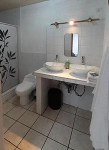 a bathroom with two sinks and a toilet at Hotel Bluehouse in Guatemala