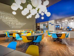 a dining room with tables and chairs and chandeliers at ibis budget SP Centro Sao Joao in Sao Paulo