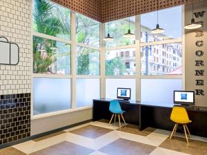 a lobby with two desks and two chairs and windows at ibis budget SP Centro Sao Joao in Sao Paulo