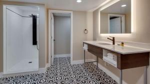 a bathroom with a sink and a mirror at The Hub Murray Hill, BW Premier Collection in New Providence