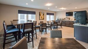 a living room with tables and chairs and a kitchen at The Westfield Inn, BW Signature Collection in Westfield