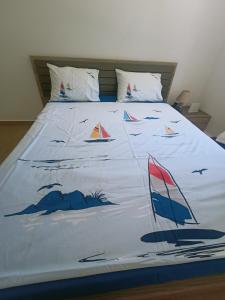 a bed with a comforter with boats on it at Anika in Sutomore