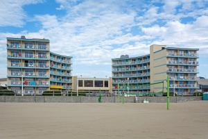 two tall buildings on the beach next to a beach at Quality Inn & Suites Oceanfront in Virginia Beach