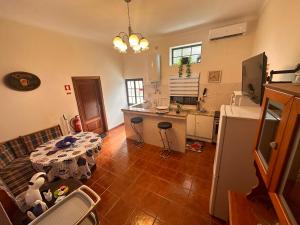 a kitchen with a table in the middle of a room at Casa da Amendoeira Covelinhas in Peso da Régua