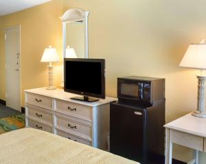 a bedroom with a dresser with a television and a microwave at Quality Inn & Suites Oceanfront in Virginia Beach