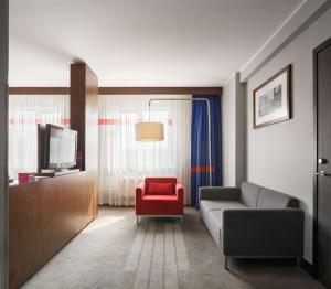 a living room with a couch and a red chair at Park Inn by Radisson Sheremetyevo Airport Moscow in Khimki