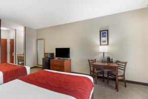 a hotel room with two beds and a desk with a desk at Comfort Inn & Suites in Rapid City