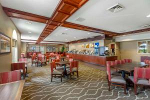 um restaurante com mesas e cadeiras e um bar em Comfort Inn & Suites em Rapid City