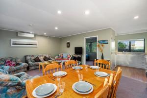 a living room with a table and a couch at Hoani Honey - Kuratau Holiday Home in Kuratau