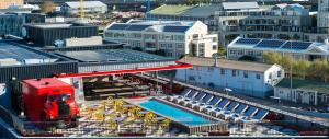 een rode truck staat geparkeerd naast een zwembad bij Radisson RED Hotel V&A Waterfront Cape Town in Kaapstad