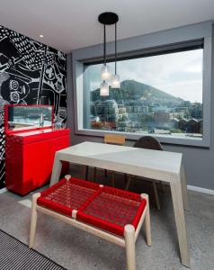 Zimmer mit einem Tisch, einer Bank und einem Fenster in der Unterkunft Radisson RED Hotel V&A Waterfront Cape Town in Kapstadt
