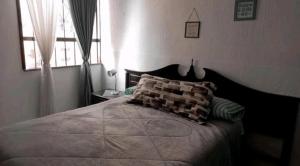 sypialnia z dużym łóżkiem i oknem w obiekcie Casa Celeste w mieście Morelia