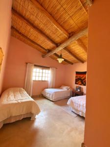 - une chambre avec deux lits et un plafond en bois dans l'établissement hosteria castillos de huichaira, à Maimará