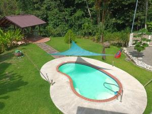 un patio trasero con piscina y cenador en Yethan house, en Uvita