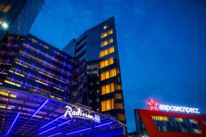 un edificio alto con una señal de neón delante de él en Radisson Blu Hotel Moscow Sheremetyevo Airport, en Khimki