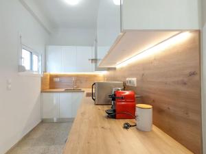 a kitchen with a red appliance on a wooden floor at Athens Divas Soul Suite in Athens