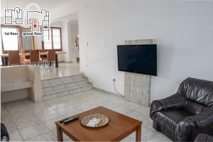a living room with a couch and a tv and a table at Great Villa Philipi in Krinídhes