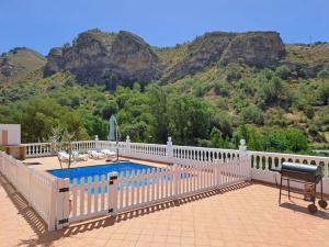ein weißer Zaun um einen Pool mit Bergen im Hintergrund in der Unterkunft Edelweiss, Casa Rural in Granada