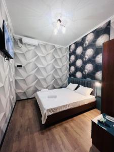 een slaapkamer met een bed en een tv. bij Cosmos Hotel in Bisjkek