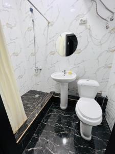 een badkamer met een toilet en een wastafel bij Cosmos Hotel in Bisjkek