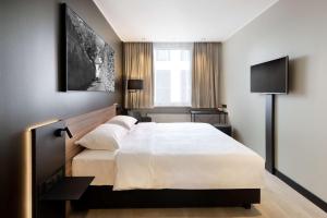 a bedroom with a large white bed and a television at Park Inn by Radisson Central Tallinn in Tallinn