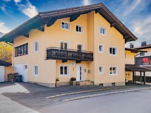 Un grand bâtiment jaune avec balcon est disponible. dans l'établissement Brixen 1, à Brixen im Thale