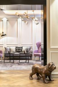 a bronze dog statue sitting on the floor in a living room at Holmes Hotel London in London