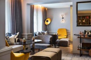 un soggiorno con divano, sedie e tavolo di Holmes Hotel London a Londra