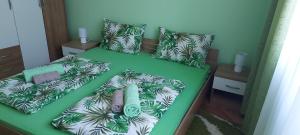 uma cama verde com folhas verdes em Apartman ,,Milica'' em Donji Milanovac