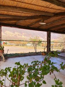 une terrasse couverte avec vue sur un champ et les montagnes dans l'établissement hosteria castillos de huichaira, à Maimará