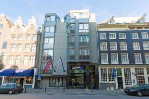 un grand bâtiment dans une rue de la ville avec des bâtiments dans l'établissement Radisson Blu Hotel, Amsterdam City Center, à Amsterdam
