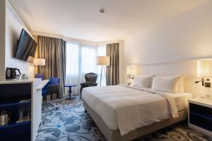 ein Hotelzimmer mit einem Bett und einem Schreibtisch in der Unterkunft Radisson Blu Hotel, Amsterdam City Center in Amsterdam