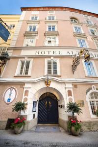 a building with a hotel entrance with flowers in front of it at Radisson Blu Hotel Altstadt in Salzburg