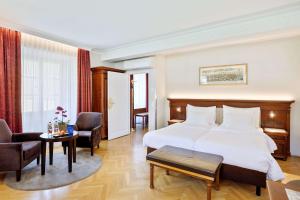 ザルツブルクにあるラディソン サス ホテル アルトシュタットのベッド、テーブル、椅子が備わるホテルルームです。