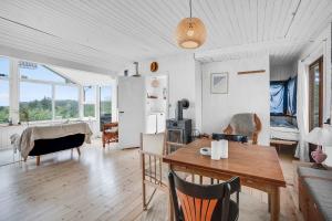 een woonkamer met een tafel en een eetkamer bij Cozy Beach House In Northern Part Of Seeland in Vejby