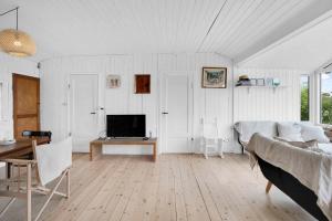 een witte woonkamer met een bed en een tafel bij Cozy Beach House In Northern Part Of Seeland in Vejby