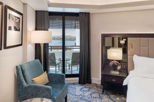 a hotel room with a bed and a chair and a window at Radisson Blu Hotel, Dubai Deira Creek in Dubai