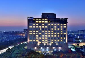 un grande edificio con luci accese in una città di notte di Radisson Blu Hotel, Indore a Indore