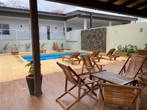 une terrasse avec des chaises, une table et une piscine dans l'établissement Aires de Cataratas, à Puerto Iguazú