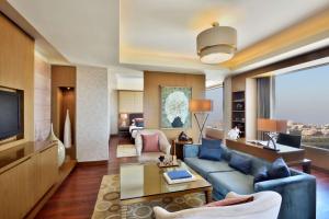 a living room with a couch and a tv at Radisson Blu Hotel, Indore in Indore