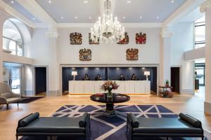 a lobby with a waiting area and a chandelier at The Edwardian Manchester, A Radisson Collection Hotel in Manchester