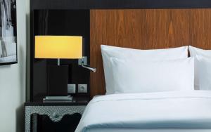 a bedroom with a bed and a lamp on a night stand at Radisson Blu Hotel, Greater Noida in Greater Noida