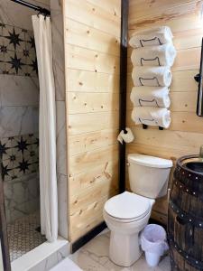 y baño con aseo, ducha y toallas. en Bourbon Barrel Cottages #2 of 5 on Kentucky trail en Lawrenceburg