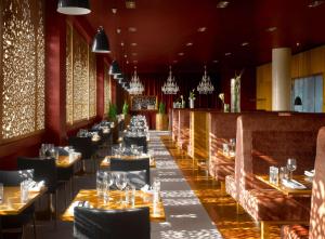 a dining room with tables and chairs and chandeliers at Radisson Blu Hotel, Liverpool in Liverpool