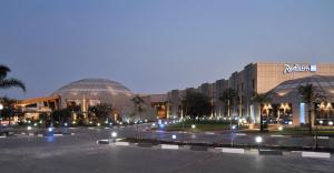 a building with two domes in a parking lot at night at Radisson Blu Hotel Lusaka in Lusaka