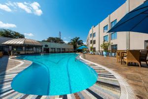 a large blue swimming pool next to a building at Radisson Blu Hotel Lusaka in Lusaka