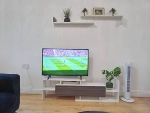 a living room with a flat screen tv on a table at Heronsgate GH015 in Gravesend