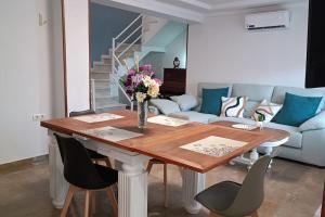 Una mesa de comedor con sillas y un sofá. en Casa con piscina y barbacoa a 3 kilómetros de la Alhambra, en Huétor Vega