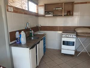 a small kitchen with a sink and a stove at ANA POIPA CANEDO in Senador Canedo
