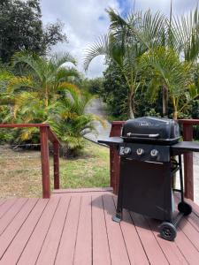 - un grill noir assis sur une terrasse en bois dans l'établissement Country Cottage in Papa Bay, à Papa Bay Estates 27 autres photos